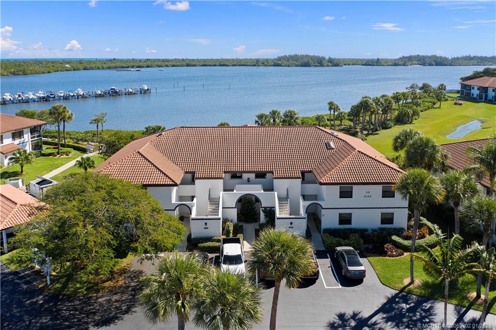 an aerial view of a house with a garden and lake view