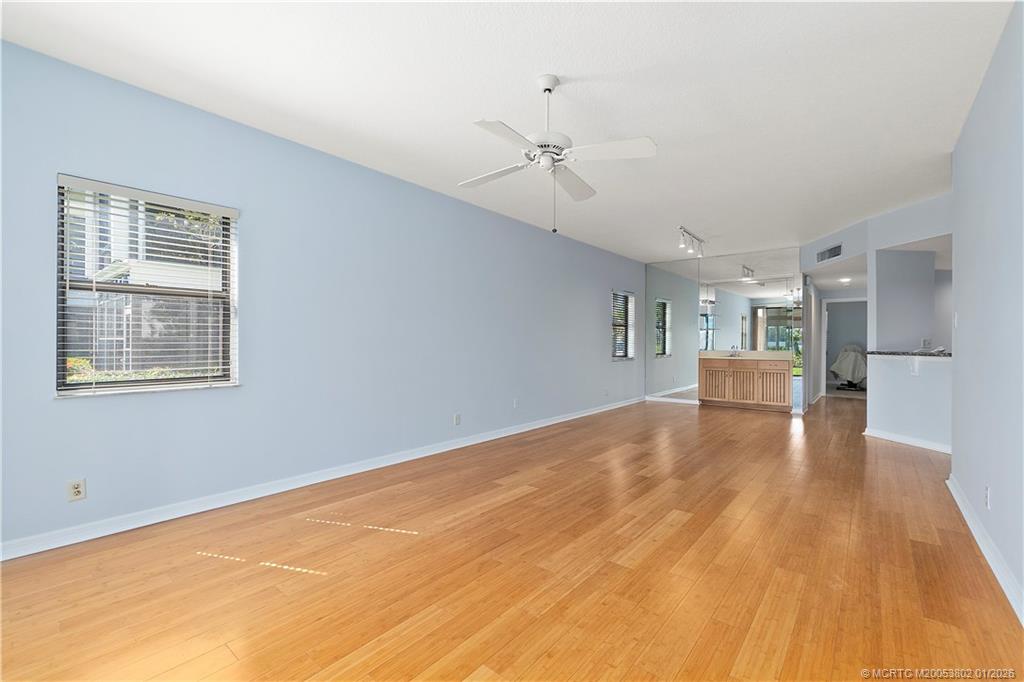 6122 Southeast Landing Way, Unit 4 Stuart, FL 34997 - Photo 16 of 23 a view of empty room with wooden floor and ceiling fan