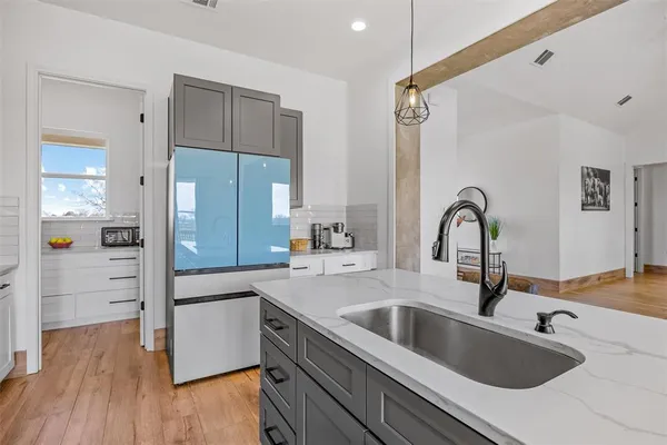 a kitchen with a refrigerator sink and cabinets