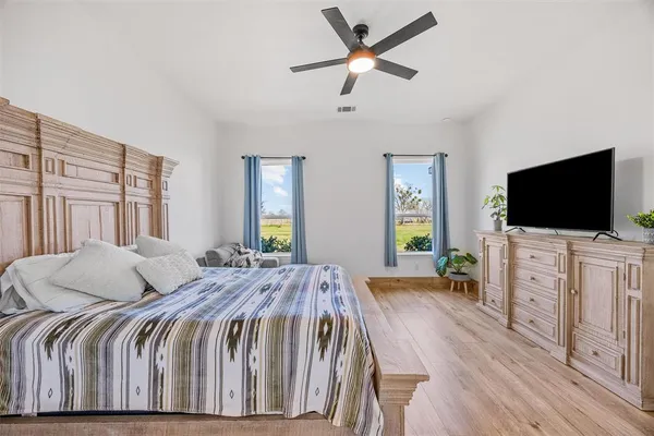 a bedroom with a bed and a flat screen tv on dresser