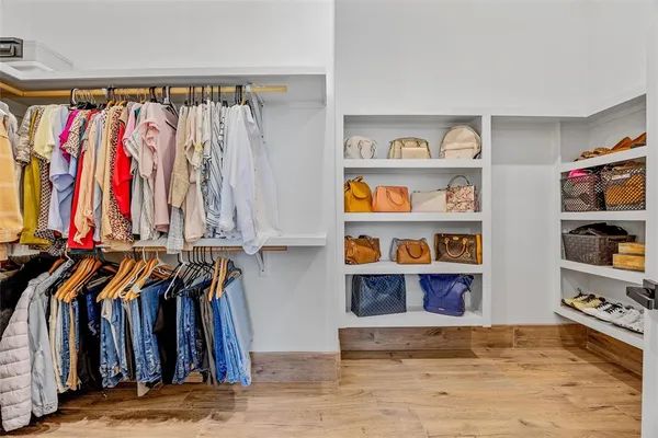 a view of walk in closet with clothes and shoes