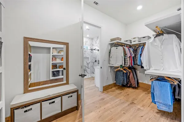 a view of walk in closet with clothes and shoes