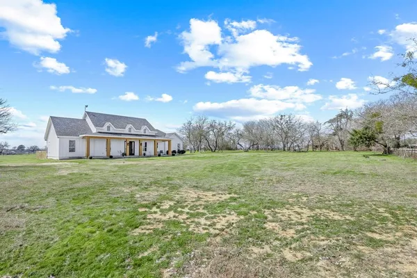 a view of a house with yard and sitting area