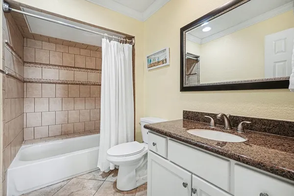 a bathroom with a granite countertop sink a toilet and bathtub