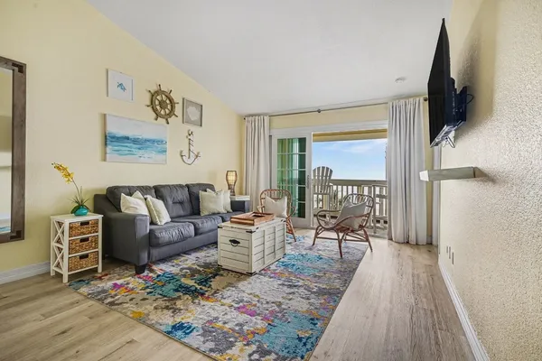 a living room with furniture wooden floor and a flat screen tv