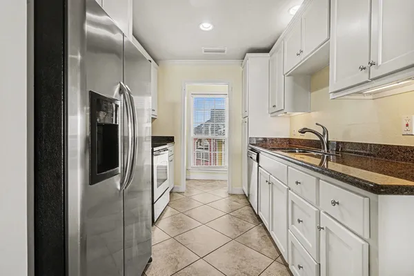 a kitchen with granite countertop a refrigerator and a sink