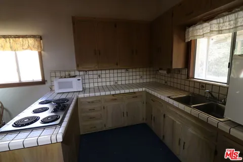 a kitchen that has a cabinets a sink a stove and a refrigerator