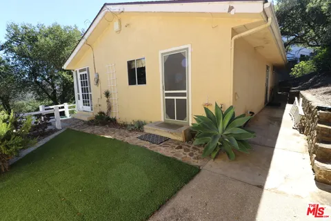 a view of a yard with plants and trees