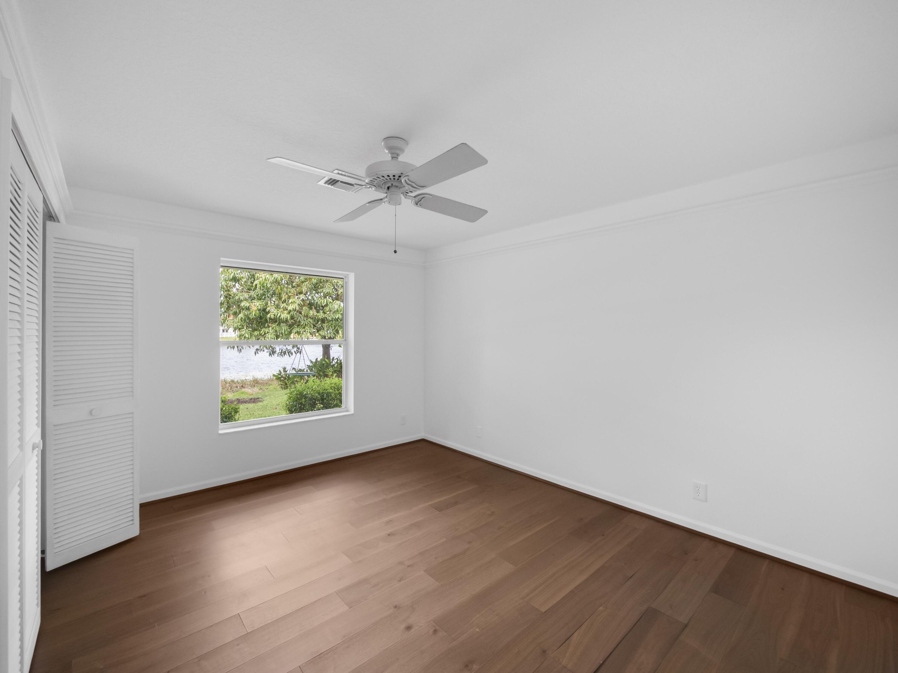 6279 Longleaf Pine Drive Jupiter, FL 33458 - Photo 16 of 33 an empty room with wooden floor and windows