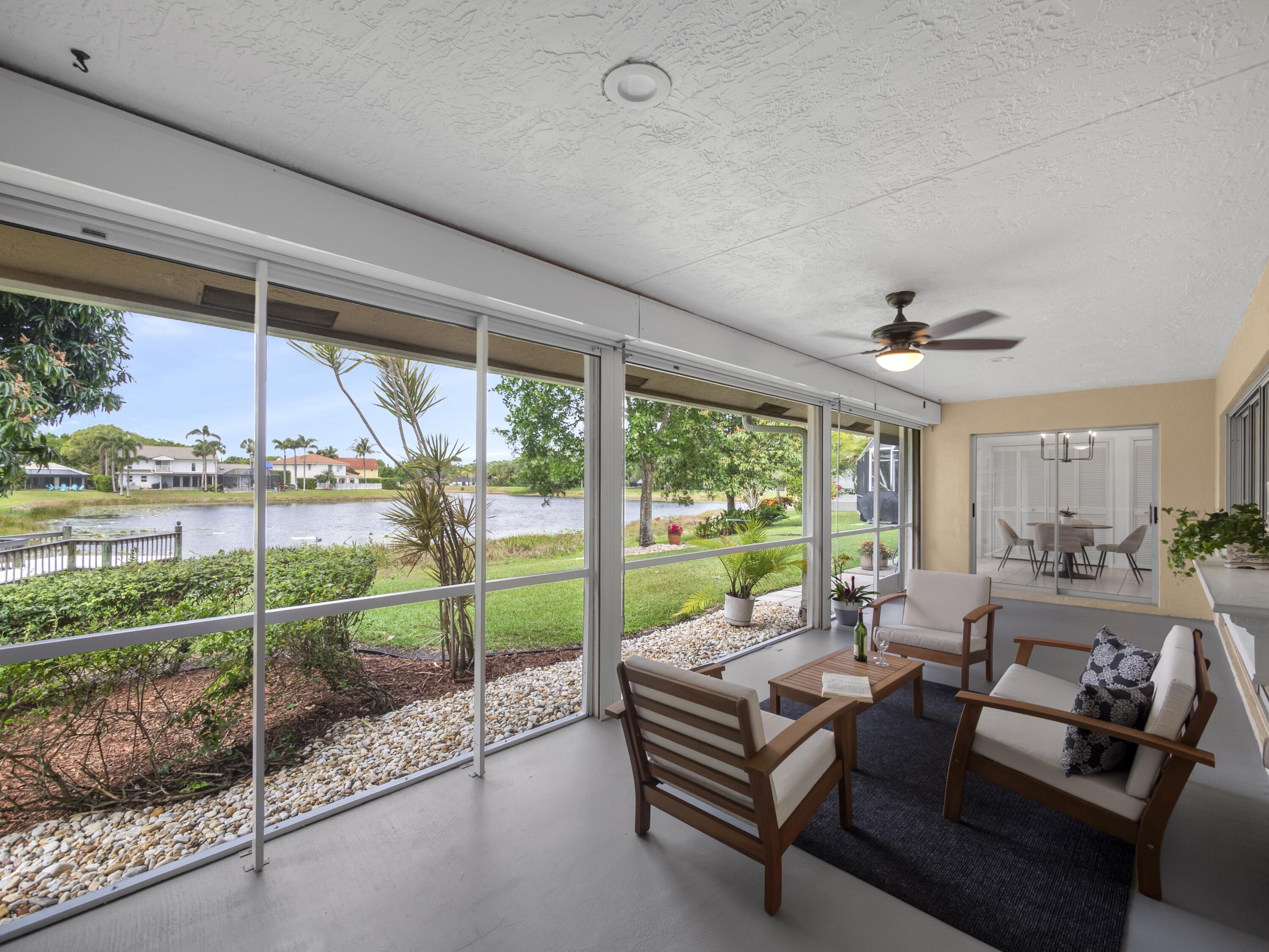 6279 Longleaf Pine Drive Jupiter, FL 33458 - Photo 18 of 33 a living room with furniture and a floor to ceiling window