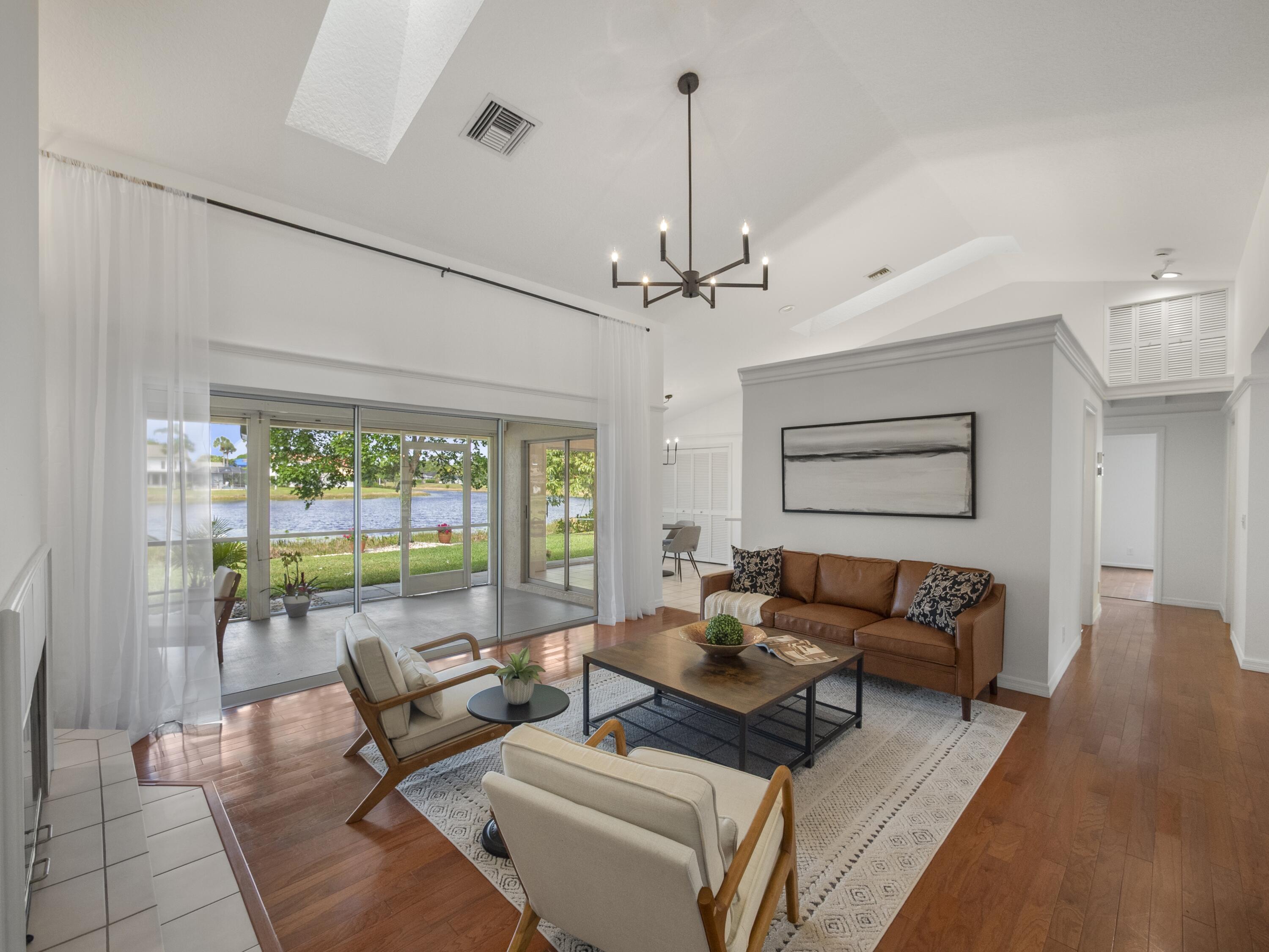 6279 Longleaf Pine Drive Jupiter, FL 33458 - Photo 2 of 33 a living room with furniture and a floor to ceiling window