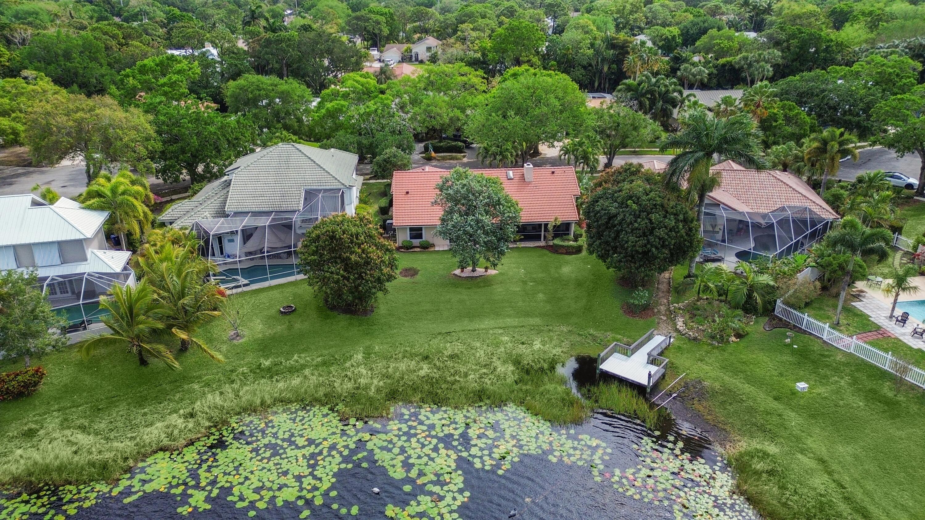 6279 Longleaf Pine Drive Jupiter, FL 33458 - Photo 22 of 33 a view of a garden with plants and a bench