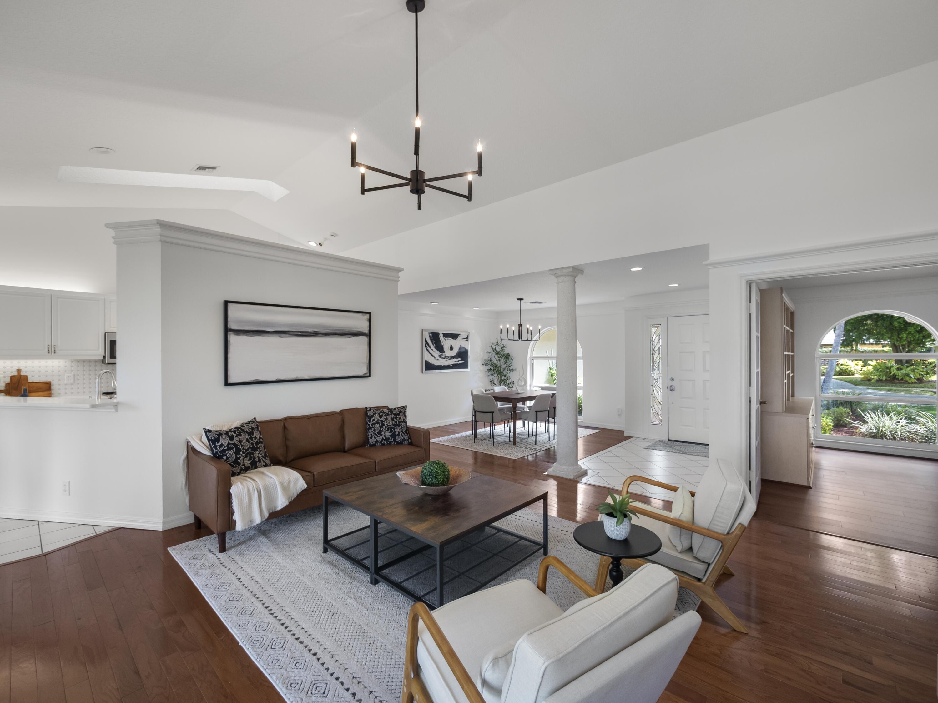 6279 Longleaf Pine Drive Jupiter, FL 33458 - Photo 3 of 33 a living room with furniture a chandelier and a wooden floor