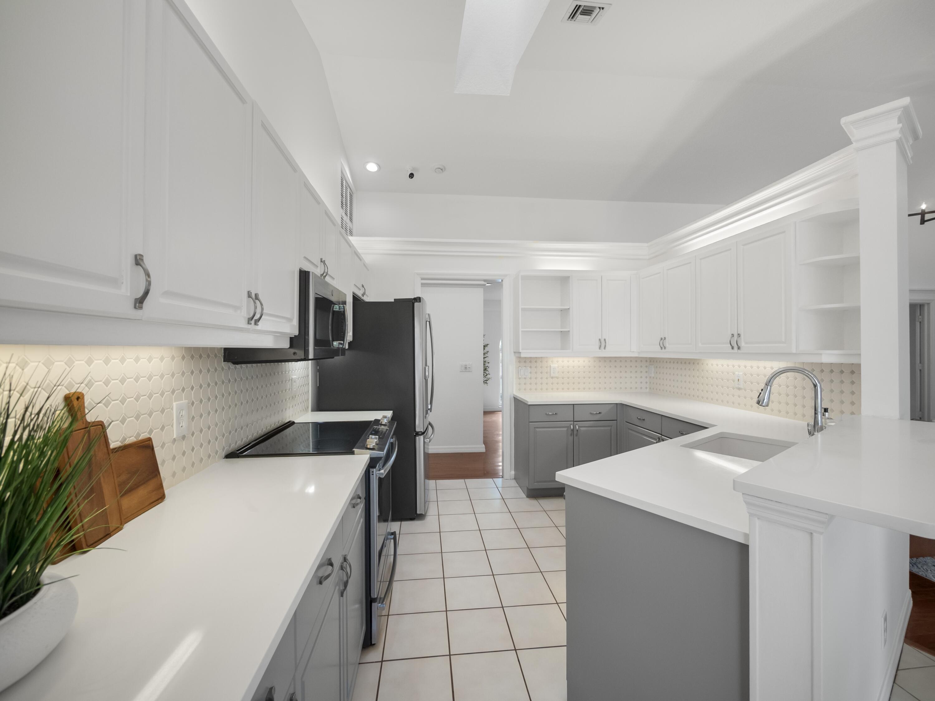 6279 Longleaf Pine Drive Jupiter, FL 33458 - Photo 7 of 33 a kitchen with stainless steel appliances granite countertop a sink and a refrigerator