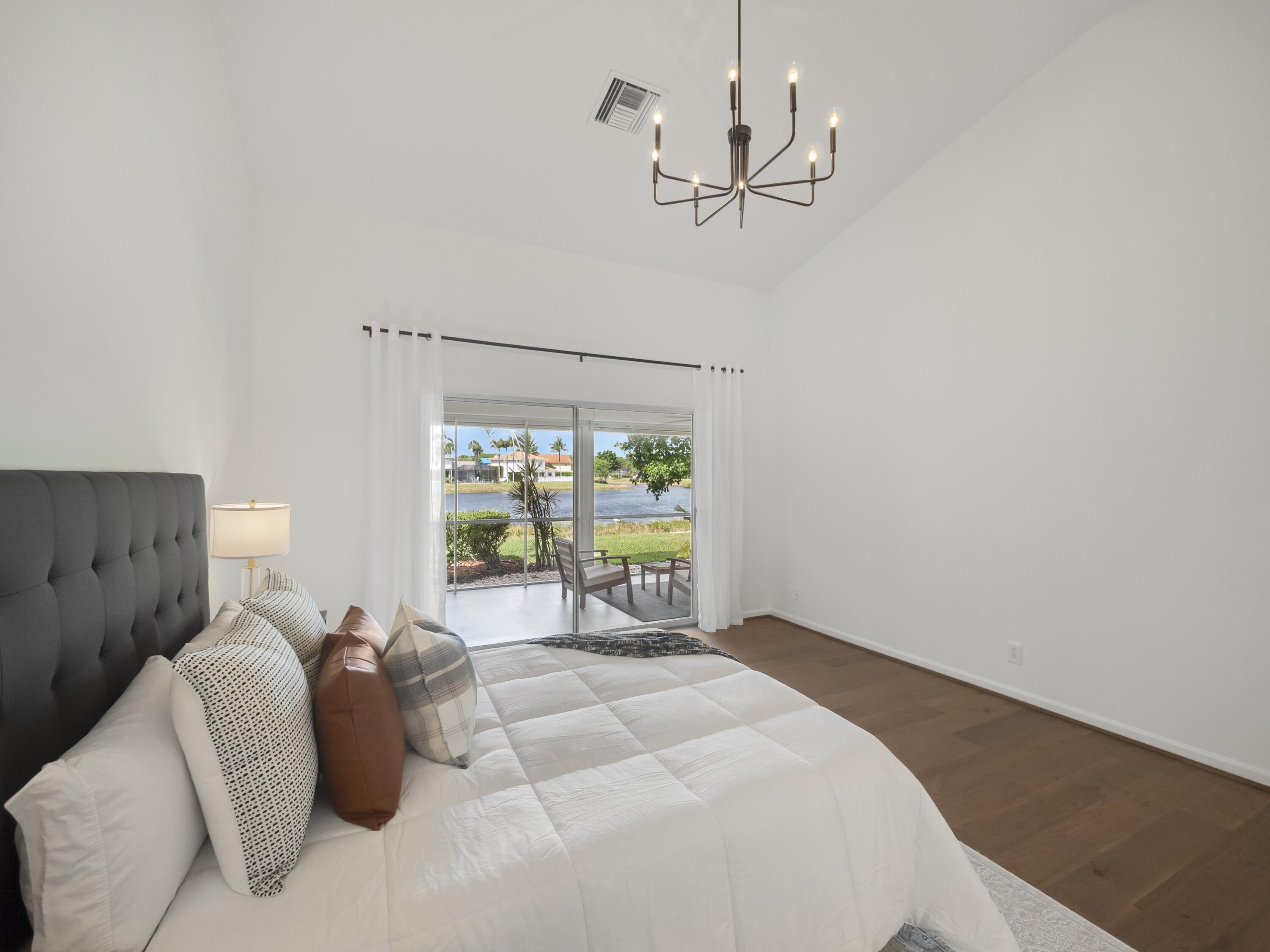 6279 Longleaf Pine Drive Jupiter, FL 33458 - Photo 9 of 33 a bed room with a bed and a chandelier