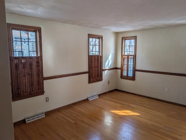 a view of a room with a ceiling fan and wooden floor