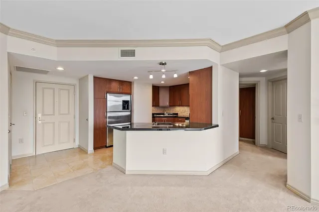 a kitchen with stainless steel appliances kitchen island a large counter top and a refrigerator