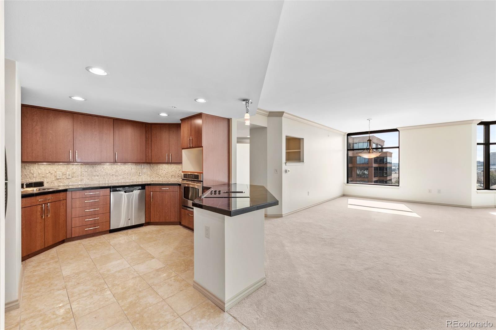 8100 East Union Avenue, Unit 814 Denver, CO 80237 - Photo 8 of 38 a kitchen with stainless steel appliances kitchen island granite countertop a refrigerator and a stove top oven