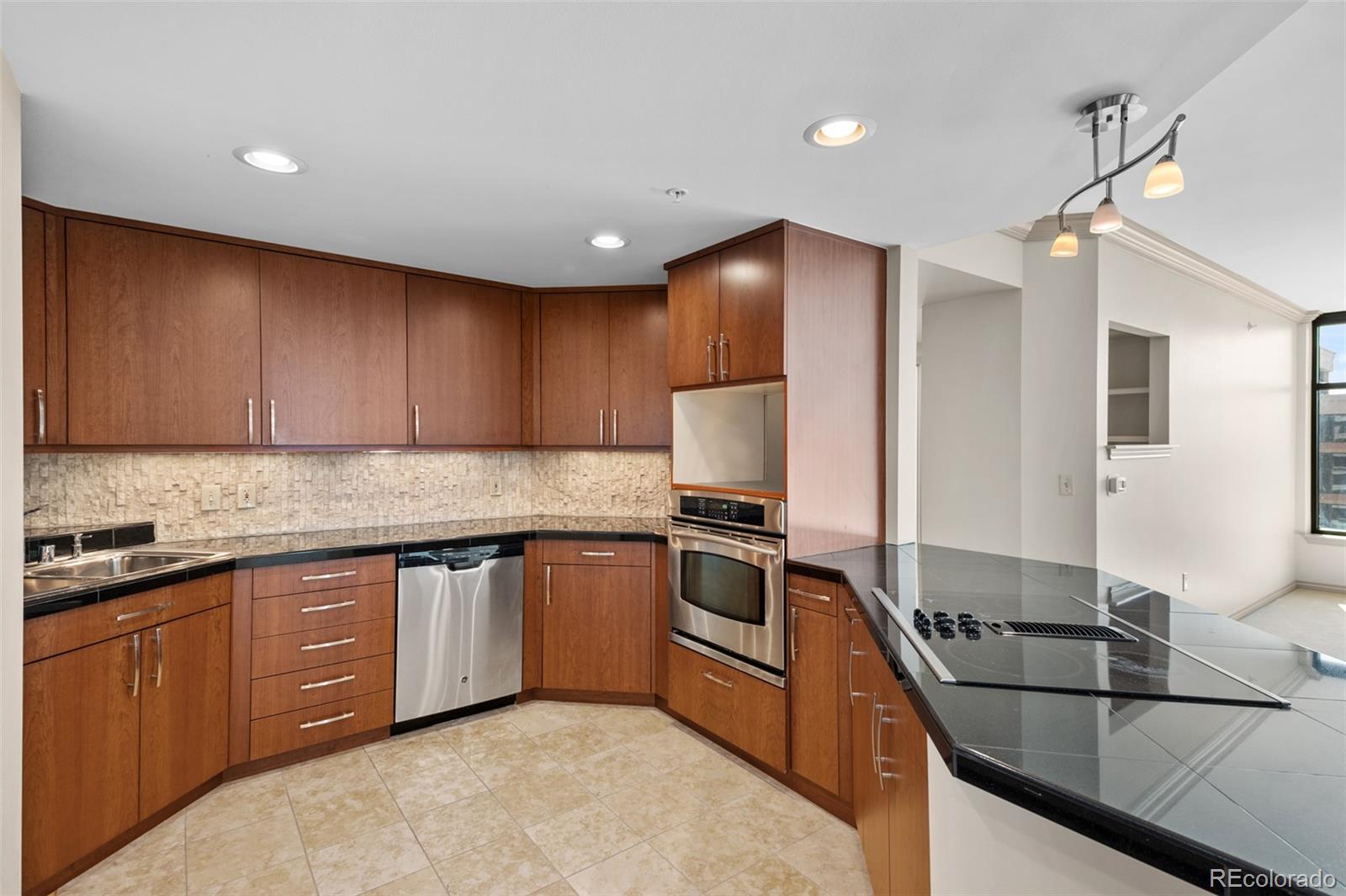 8100 East Union Avenue, Unit 814 Denver, CO 80237 - Photo 9 of 38 a kitchen with stainless steel appliances granite countertop a sink stove and refrigerator