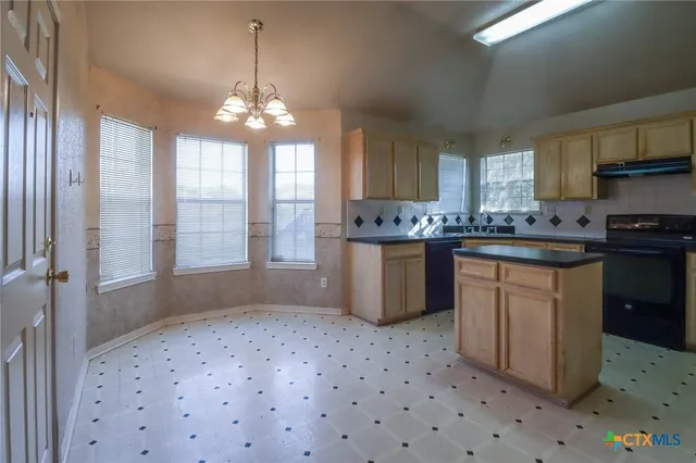 a kitchen with stainless steel appliances a sink window and cabinets