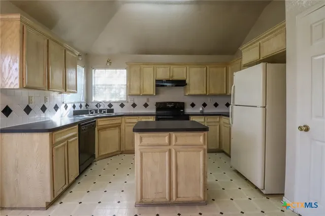 a kitchen with granite countertop white cabinets and white appliances