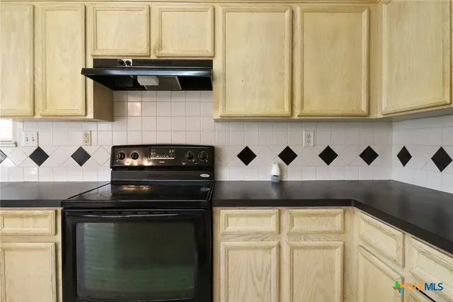 a kitchen with stainless steel appliances granite countertop white cabinets and a stove