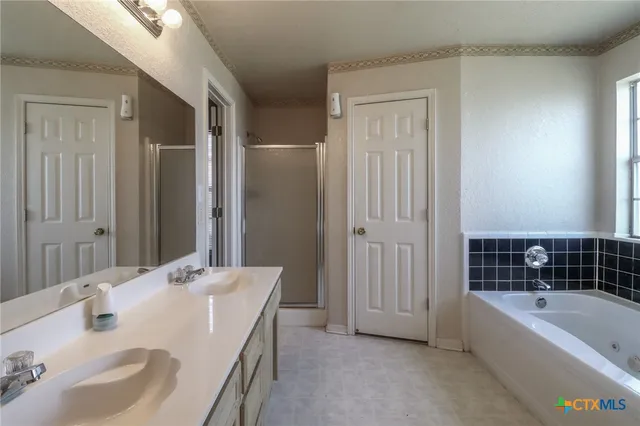 a bathroom with a tub sink and mirror