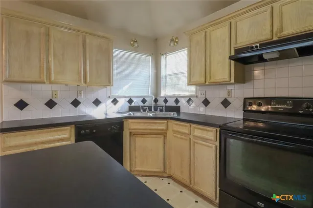 a kitchen with stainless steel appliances granite countertop a sink stove and cabinets