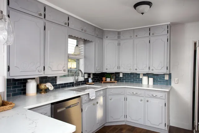 a kitchen with stainless steel appliances granite countertop a sink a stove and cabinets