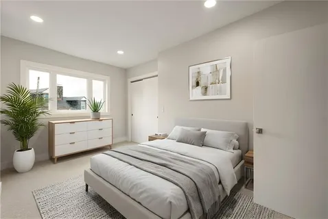 a bedroom with a large bed and a potted plant