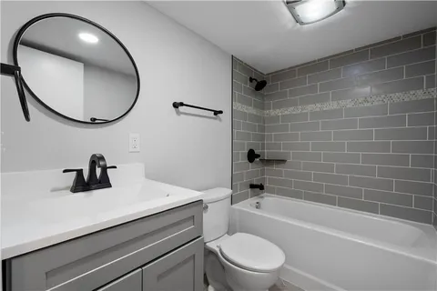 a bathroom with a sink a toilet and a mirror