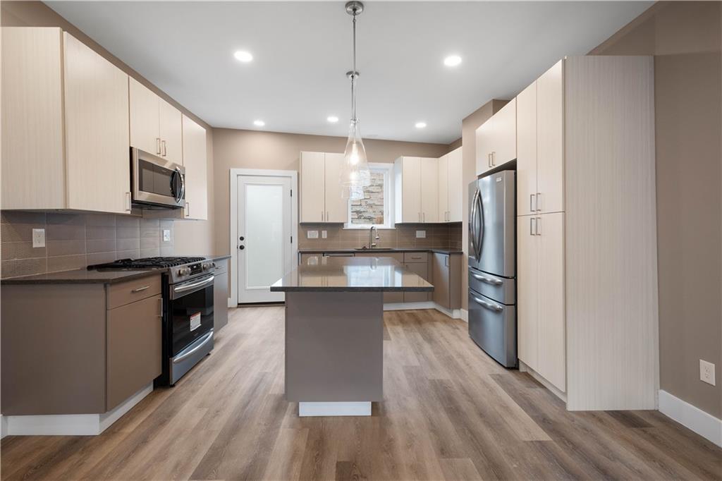 807 McCandless Avenue Pittsburgh, PA 15201 - Photo 2 of 24 a large kitchen with stainless steel appliances a refrigerator a stove a sink cabinets and wooden floor