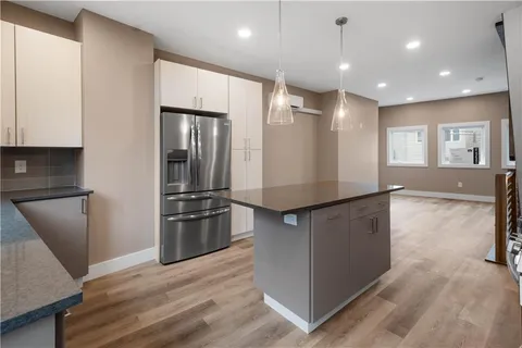 a kitchen with stainless steel appliances granite countertop a refrigerator and a stove top oven