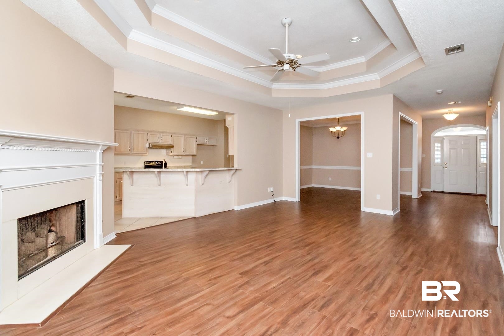 6117 Lennox Place Mobile, AL 36693 - Photo 10 of 39 Unfurnished living room with visible vents, a fireplace with flush hearth, a raised ceiling, ceiling fan with notable chandelier, and ornamental molding