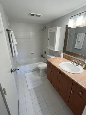 a bathroom with a double vanity sink toilet mirror and shower