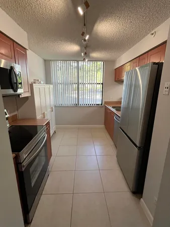 a view of kitchen with refrigerator stove and wooden floor