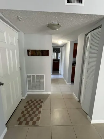 a view of a hallway with entryway and kitchen view