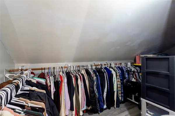 a view of walk in closet with clothes and shoes