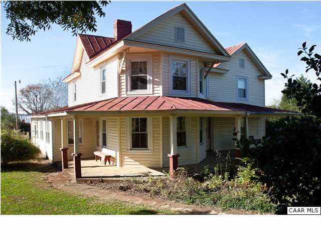 791 Cedar Grove Road Ruckersville, VA 22968 - Photo 1 of 18 a view of a white house with large windows and a table and chairs under an umbrella