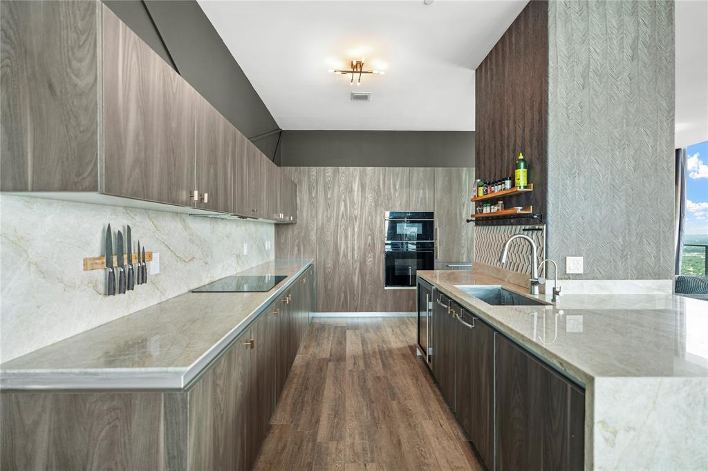 480 Northeast 31st Street, Unit 5104A Miami, FL 33137 - Photo 11 of 26 a kitchen with kitchen island granite countertop a sink stove and cabinets