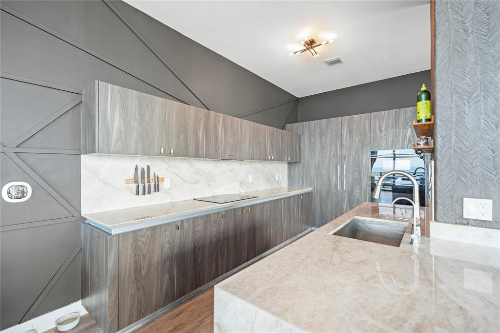 480 Northeast 31st Street, Unit 5104A Miami, FL 33137 - Photo 10 of 26 a kitchen with a sink a stove and cabinets