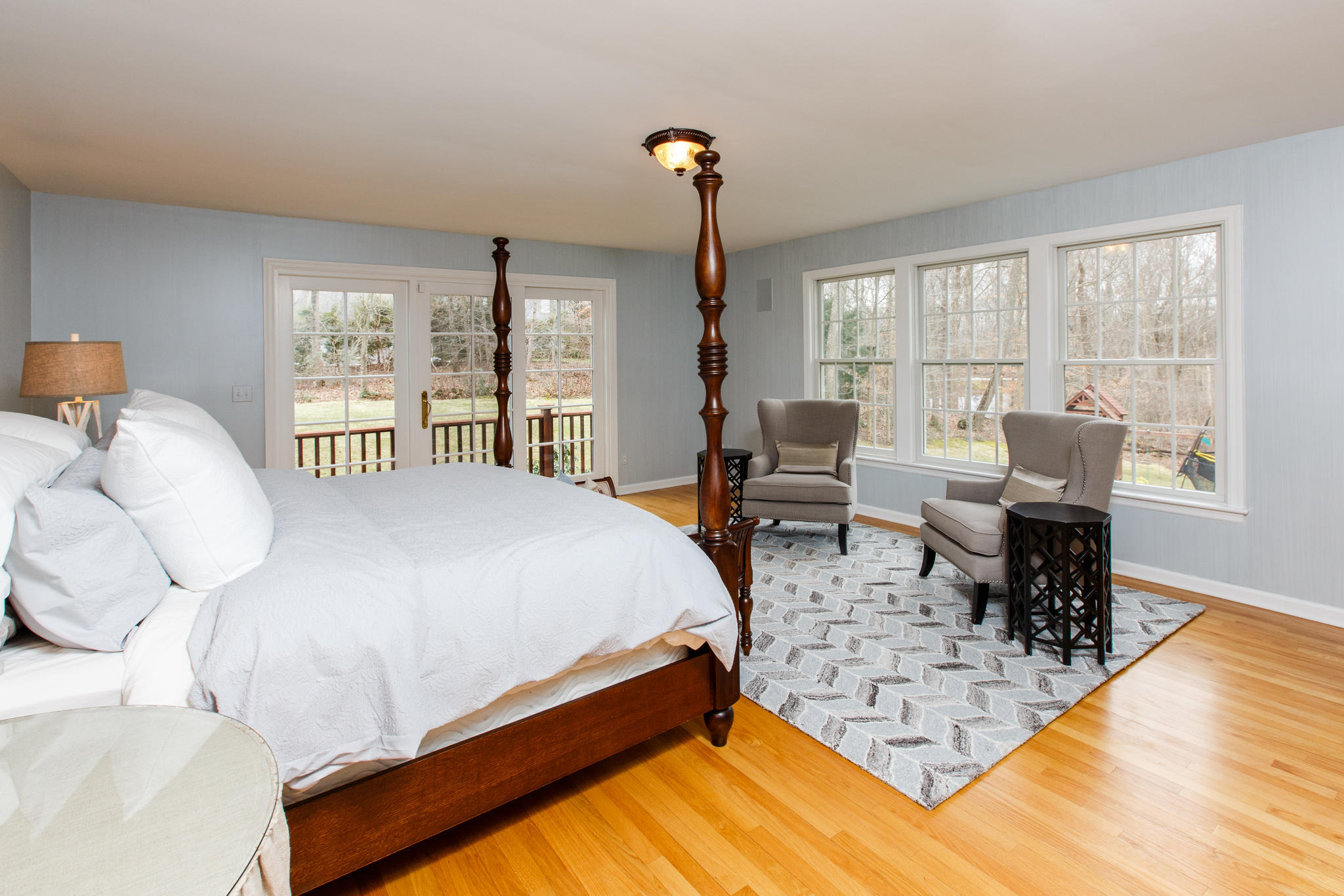 54 Rocky Brook Road New Canaan, CT 06840 - Photo 16 of 25 a spacious bedroom with a bed a table and large windows