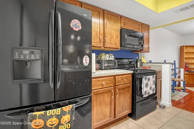 a kitchen with stainless steel appliances granite countertop a refrigerator a stove and a sink with wooden floor