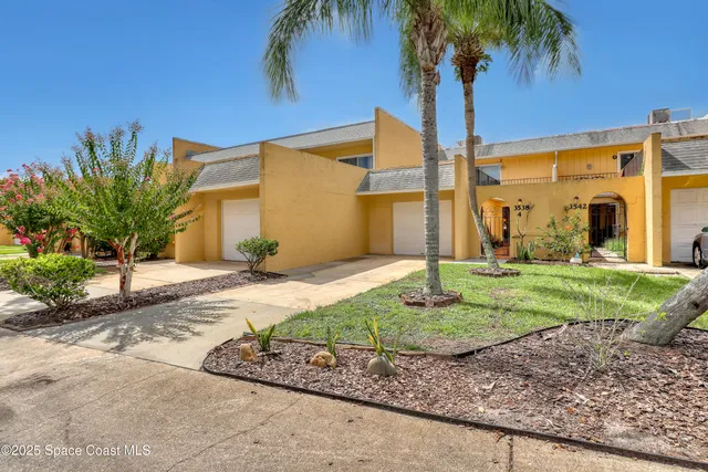a front view of a house with garden and plants