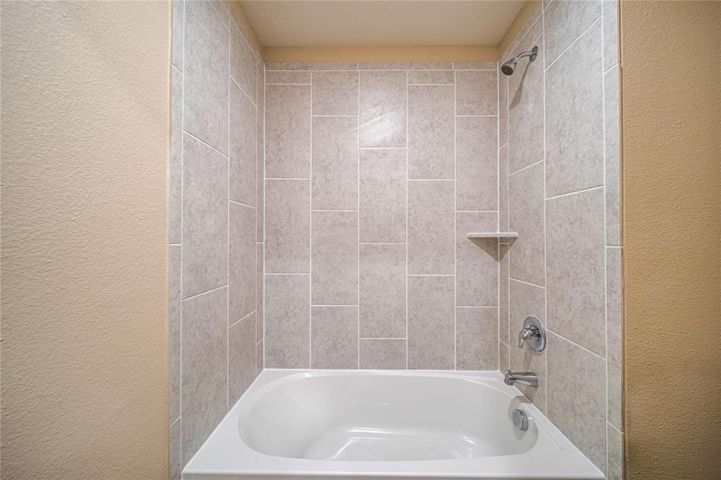 274 Honeysuckle Lane Princeton, TX 75407 - Photo 29 of 35 Full bath featuring a textured wall and washtub / shower combination