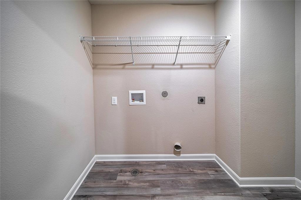 274 Honeysuckle Lane Princeton, TX 75407 - Photo 30 of 35 Laundry room with a textured wall, dark wood-style floors, hookup for a washing machine, electric dryer hookup, and gas dryer hookup