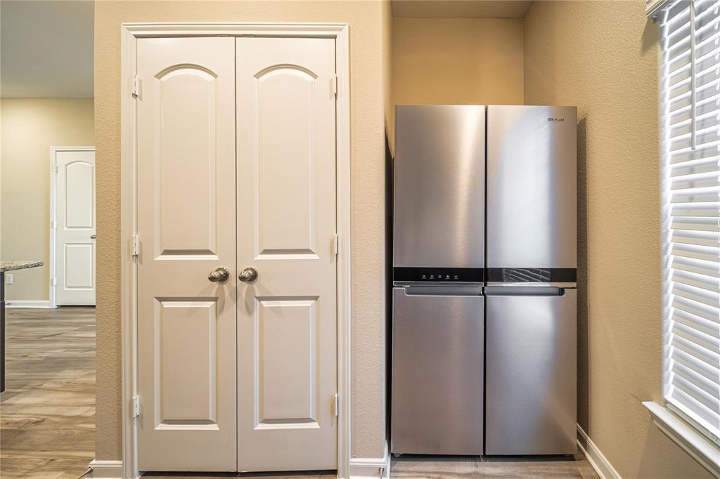 274 Honeysuckle Lane Princeton, TX 75407 - Photo 7 of 35 Kitchen with a textured wall, freestanding refrigerator, and light wood finished floors