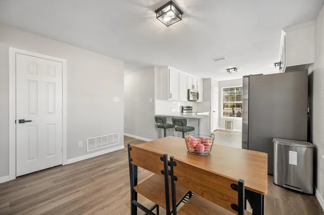 a view of a dining room with furniture and a refrigerator