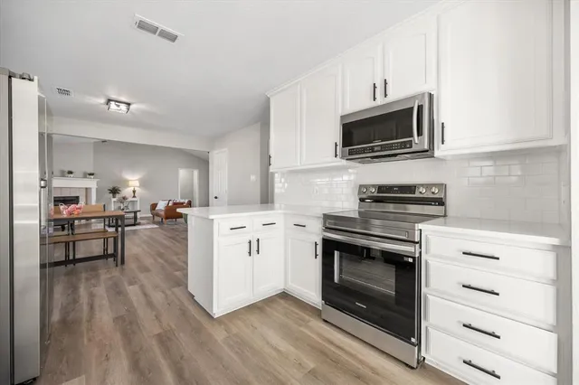 a kitchen with stainless steel appliances a stove microwave and cabinets
