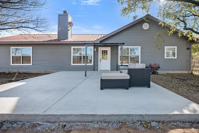 a front view of house with yard outdoor seating and covered with trees
